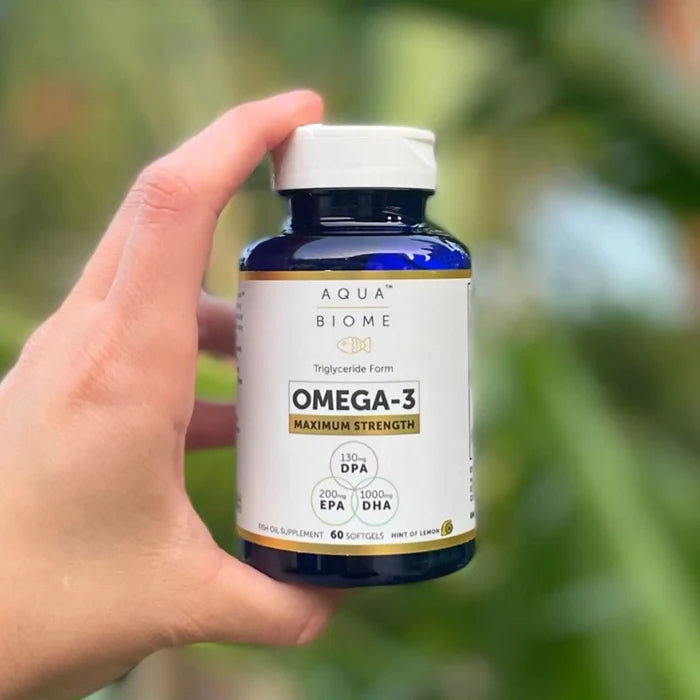 person holding a bottle of aquabiome fish oil ma strength