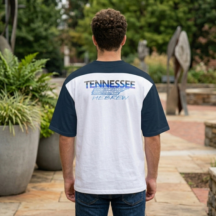 Rear view of a man in a white and navy raglan shirt featuring a "TENNESSEE HEBREW" graphic and state map outline on the upper back.